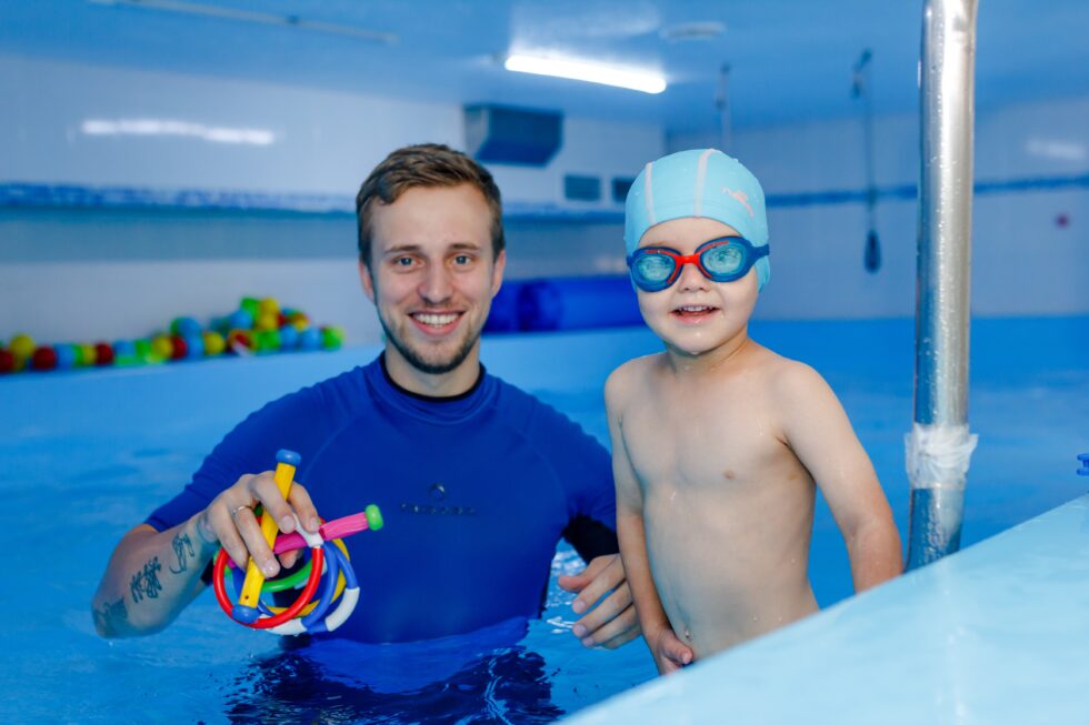 Moniteur diplômé encadrant un enfant en cours de natation à Namur